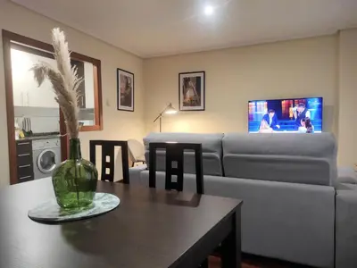 a living room with a couch and a table at 1A. Disfruta de su balcón sobre el casco viejo. in Ourense
