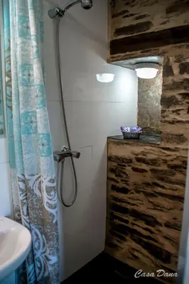 a bathroom with a shower curtain and a sink at Casa Rural Dana in Castelo
