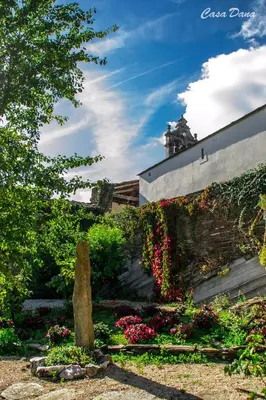 a garden with flowers and a stone wall at Casa Rural Dana in Castelo