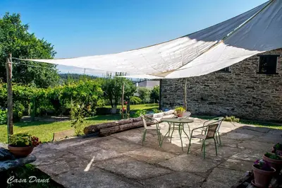 a patio with a table and chairs and a white canopy at Casa Rural Dana in Castelo