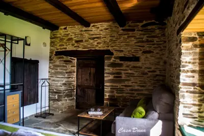 a living room with a couch and a brick wall at Casa Rural Dana in Castelo
