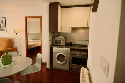 a kitchen with a washing machine and a table at 1E.Tranquilo y soleado en la Plaza de las Mercedes in Ourense
