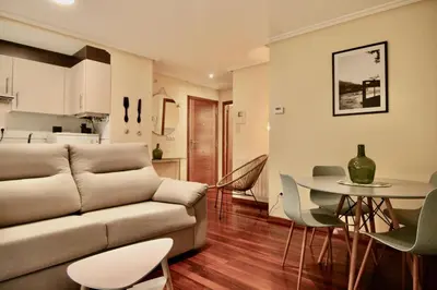 a living room with a couch and a table with chairs at 1F.Céntrico y tranquilo en la ciudad de las Burgas in Ourense