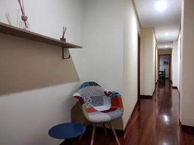 a room with a chair and a table at 2A. Dos dormitorios y balcones en el casco viejo. in Ourense
