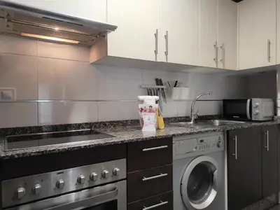 a kitchen with a sink and a washing machine at 2A. Dos dormitorios y balcones en el casco viejo. in Ourense