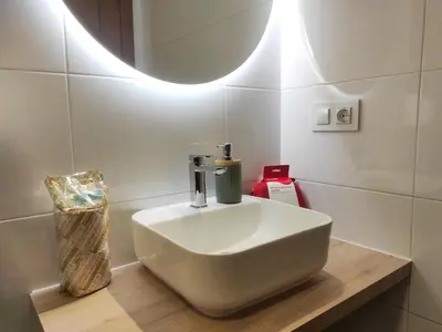 a white sink on a wooden counter in a bathroom at 2A. Dos dormitorios y balcones en el casco viejo. in Ourense