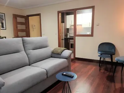 a living room with a couch and a chair at 2A. Dos dormitorios y balcones en el casco viejo. in Ourense