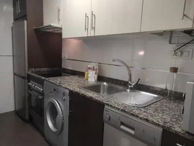 a kitchen with a sink and a washing machine at 2D.Tres dormitorios y balcón con vistas al parque in Ourense