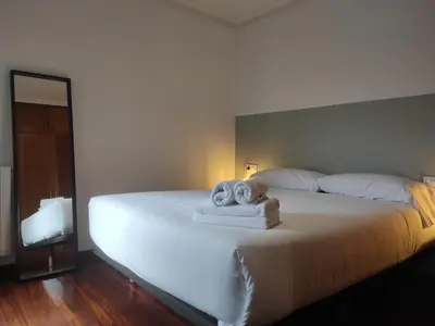 a bedroom with a bed with towels on it at 2D.Tres dormitorios y balcón con vistas al parque in Ourense