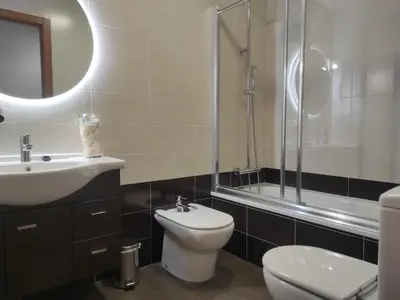 a bathroom with a toilet and a sink and a shower at 2D.Tres dormitorios y balcón con vistas al parque in Ourense