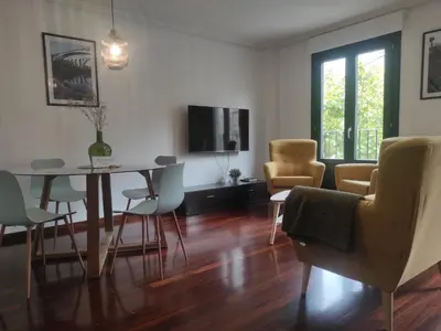 a living room with a dining room table and chairs at 2D.Tres dormitorios y balcón con vistas al parque in Ourense