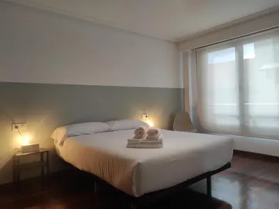 a bedroom with a bed with two towels on it at 2D.Tres dormitorios y balcón con vistas al parque in Ourense