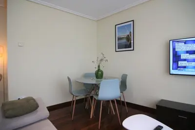 a living room with a table and chairs and a tv at 2F. El mejor lugar para descansar y vivir Ourense in Ourense