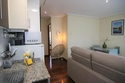 a living room with a couch and a kitchen at 2F. El mejor lugar para descansar y vivir Ourense in Ourense