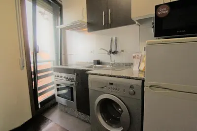 a kitchen with a washing machine and a refrigerator at 2F. El mejor lugar para descansar y vivir Ourense in Ourense