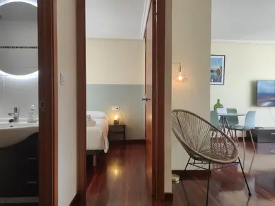 a bedroom with a bed and a chair in a room at 2F. El mejor lugar para descansar y vivir Ourense in Ourense