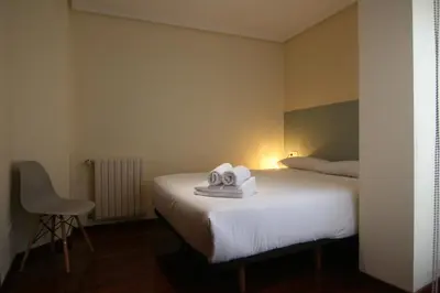 a hotel room with a bed with towels on it at 3B.Descansa y disfruta en el corazón de las Burgas in Ourense