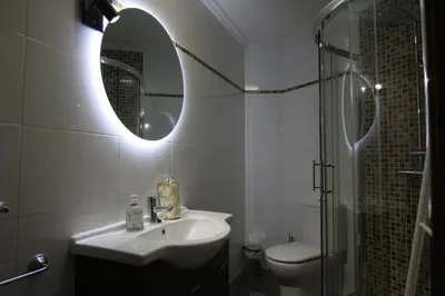 a bathroom with a sink and a mirror and a toilet at 3B.Descansa y disfruta en el corazón de las Burgas in Ourense