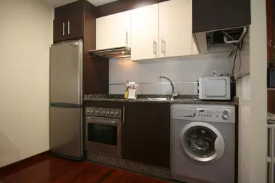 a kitchen with a refrigerator and a washing machine at 3B.Descansa y disfruta en el corazón de las Burgas in Ourense