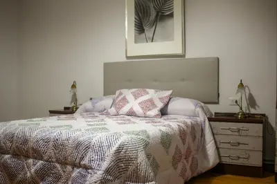 a bedroom with a bed with a blanket and a dresser at Casa Fernando in Burela de Cabo