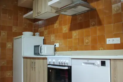a kitchen with a stove and a microwave at Casa Fernando in Burela de Cabo