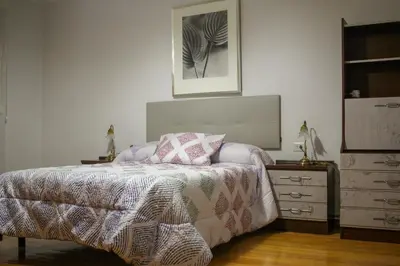 a bedroom with a bed and a dresser at Casa Fernando in Burela de Cabo