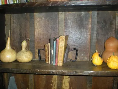 a shelf with books and vegetables on it at Hotel Rural Casa Ana in Vega de Espinareda