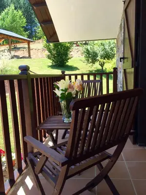 a wooden bench sitting on a porch with a vase of flowers at Hotel Rural Casa Ana in Vega de Espinareda