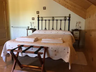 a bedroom with a large bed with a wooden frame at Hotel Rural Casa Ana in Vega de Espinareda