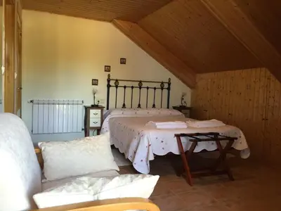 a bedroom with a bed with a table and a couch at Hotel Rural Casa Ana in Vega de Espinareda