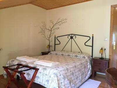 a bedroom with a bed and a dresser with a bedspread at Hotel Rural Casa Ana in Vega de Espinareda