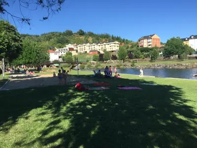 a group of people sitting on the grass in a park at Hotel Rural Casa Ana in Vega de Espinareda