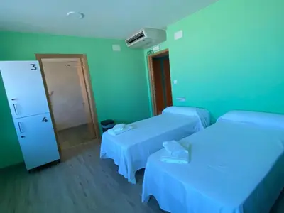 a hotel room with two beds and a mirror at O TEU SITIO in Ribadeo