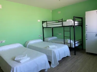 two beds in a room with green walls at O TEU SITIO in Ribadeo