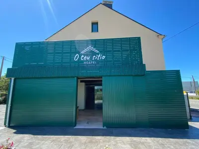 a green store front with a green garage door at O TEU SITIO in Ribadeo