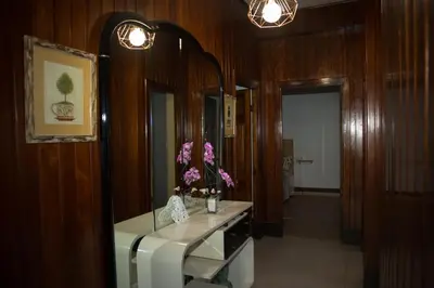 a bathroom with a mirror and a sink with flowers on it at LA CASA DEL RÍO - A 13 kilómetros de Santiago in Sigüeiro