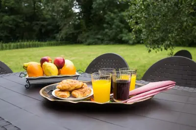 a table with a tray of fruit and orange juice at LA CASA DEL RÍO - A 13 kilómetros de Santiago in Sigüeiro