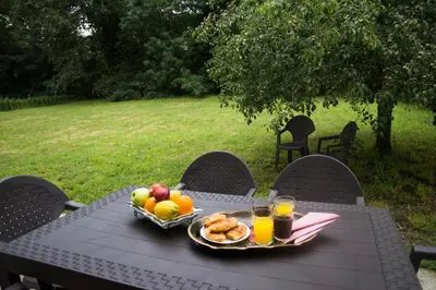 a picnic table with a bowl of fruit and glasses of orange juice at LA CASA DEL RÍO - A 13 kilómetros de Santiago in Sigüeiro
