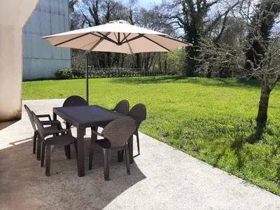 a black table with chairs and an umbrella at LA CASA DEL RÍO - A 13 kilómetros de Santiago in Sigüeiro