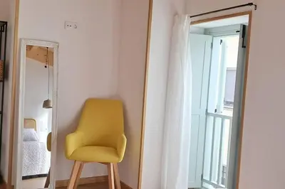a yellow chair in a room with a mirror at A Maraxe in Rinlo