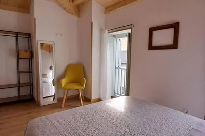 a bedroom with a bed and a yellow chair at A Maraxe in Rinlo