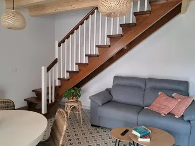 a living room with a blue couch and stairs at A Maraxe in Rinlo