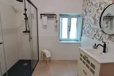 a bathroom with a shower and a sink and a mirror at A Maraxe in Rinlo