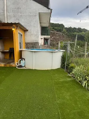 a backyard with a swimming pool and a green lawn at casa carmiña in Ourense