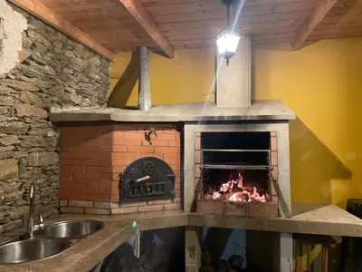 a kitchen with a brick oven and a sink at casa carmiña in Ourense