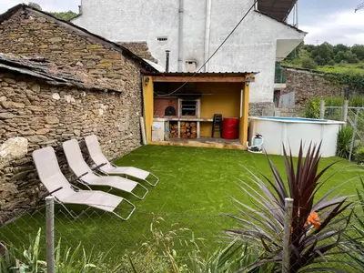 a yard with lawn chairs and a building at casa carmiña in Ourense