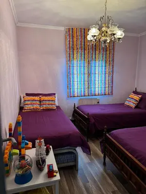 a room with two beds and a chandelier at casa carmiña in Ourense