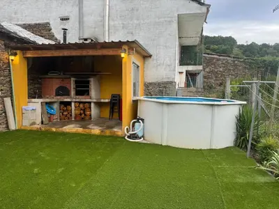 a backyard with a pool and green grass at casa carmiña in Ourense