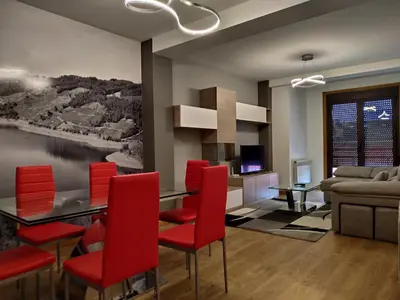 a living room with a dining table and red chairs at Casa Nicolas in Chantada