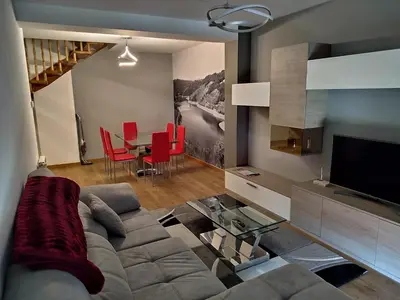 a living room with a couch and a table with red chairs at Casa Nicolas in Chantada